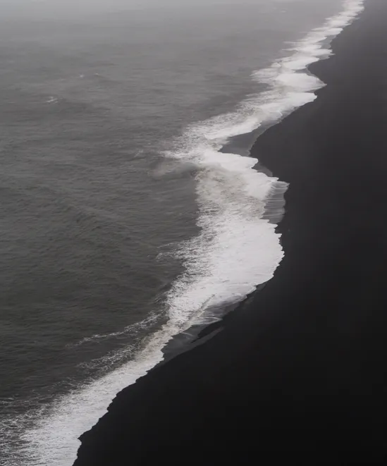 Waves crashing on a black sand beach